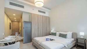 Hotellihuone, jossa on sänky, yöpöytä ja pieni ruokapöytä tuoleineen.