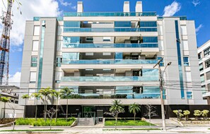 A multi-story hotel with a modern design, featuring balconies and large windows.