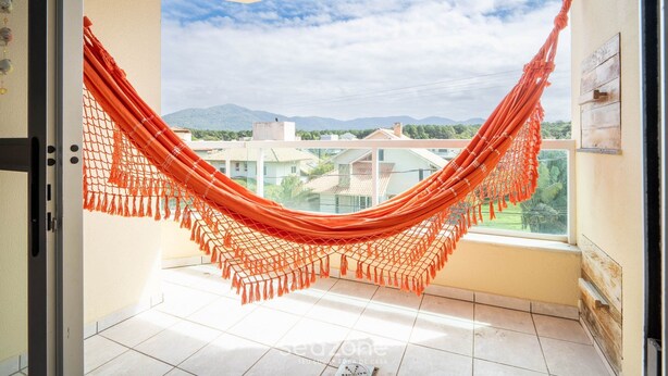 A hammock hanging in a balcony with a view of buildings and mountains. - Apt w/ Balcony & BBQ 450m From the sea Reh0203 (Florianópolis)