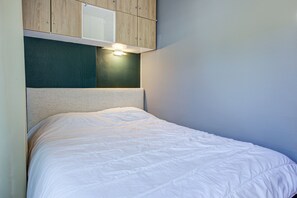 A bed with a white mattress and a headboard with a textured design.