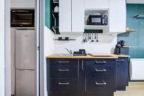 A kitchen with a built-in oven, microwave, and a coffee machine.