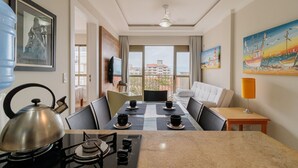 A hotel room with a dining table, chairs, a kettle, a TV, and artwork on the walls. - Apto com Vista mar em Canasvieiras Lbm401 (Florianópolis)