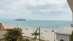 A beach with a view of the ocean and a distant island. - Apto com Vista mar em Canasvieiras Lbm401 (Florianópolis)