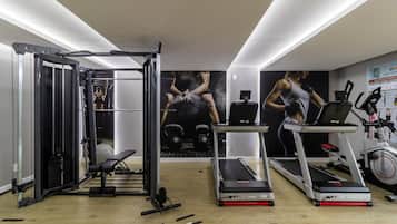 A gym with exercise equipment, treadmills, and a wall with motivational posters.