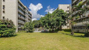 A courtyard with a playground, surrounded by multi-story buildings with balconies and air conditioning units. - Apartment With Home Office in Floripa Jfm0062 (Florianópolis)