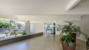 A spacious indoor area with a polished floor, a potted plant, and a glass door leading to another room. - Apartment With Home Office in Floripa Jfm0062 (Florianópolis)