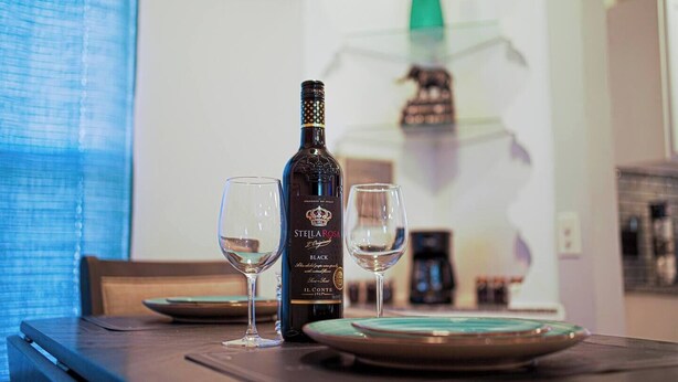 Une bouteille de vin Stella Rosa Black sur une table, avec deux verres.