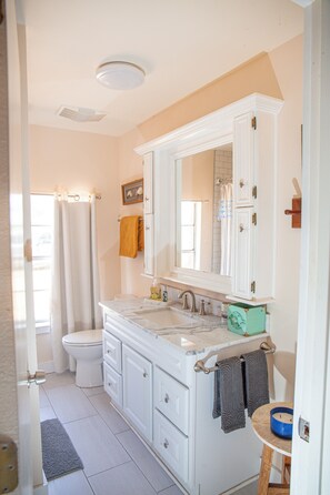 Une salle de bain avec des toilettes, un lavabo et un miroir.