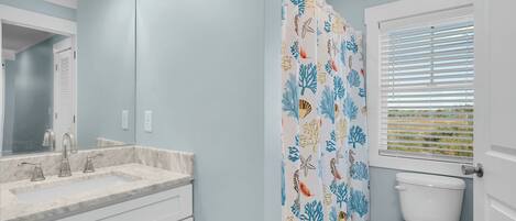 A bathroom with a white sink, mirror, and toilet.
