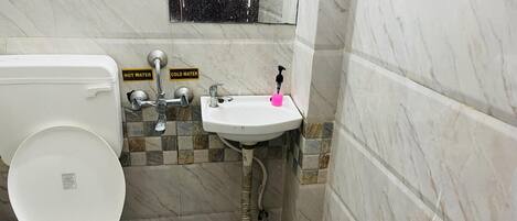 A small bathroom with a toilet, sink, and shower.