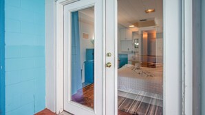 A room with a bed, a bathroom, and a door leading to another room. - Private Pool Paradise w/ Games Galore! Less than a mile to Stadium & O'Dome! (Gainesville)