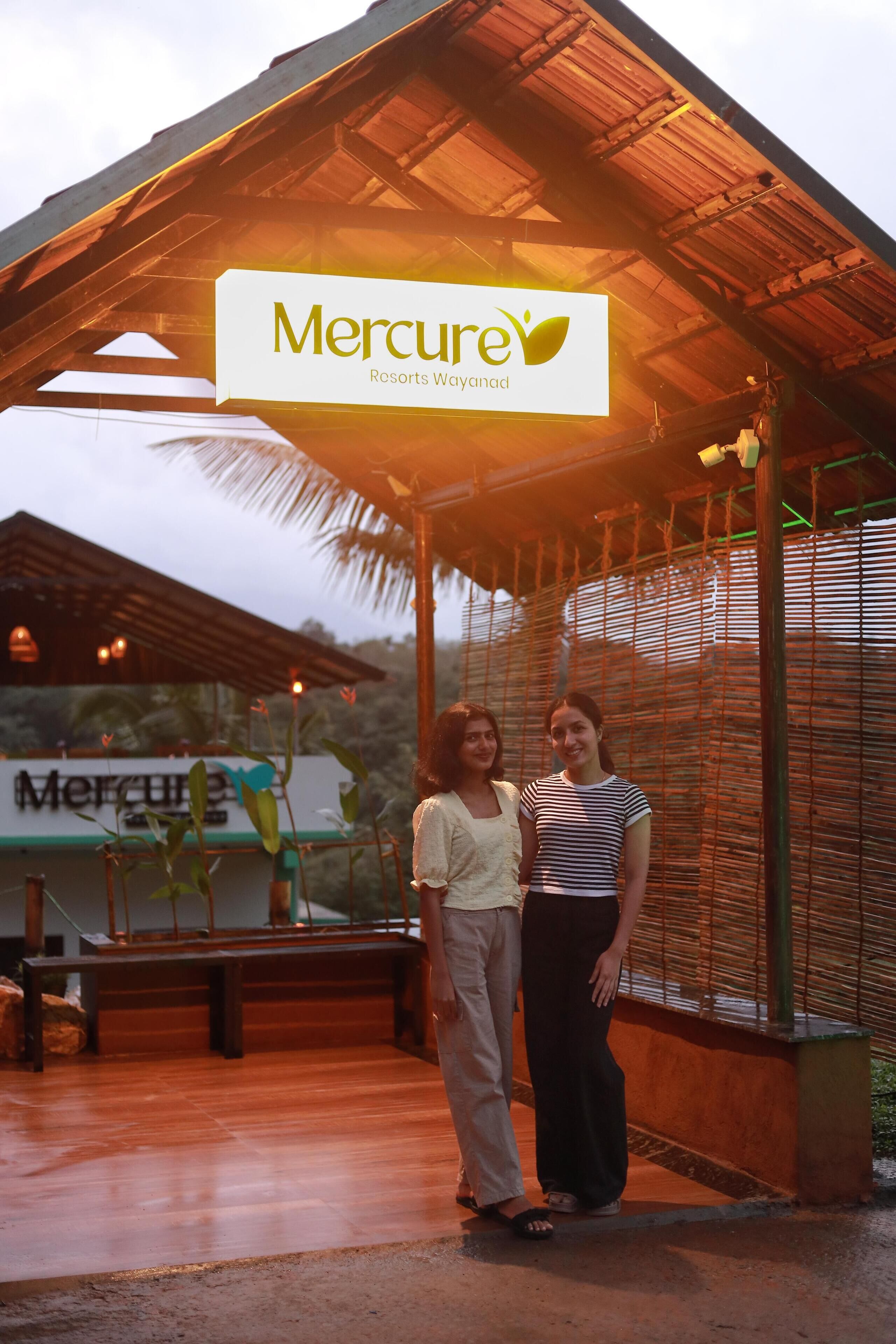 A covered outdoor area with a sign for Mercure Resorts Wayanad.