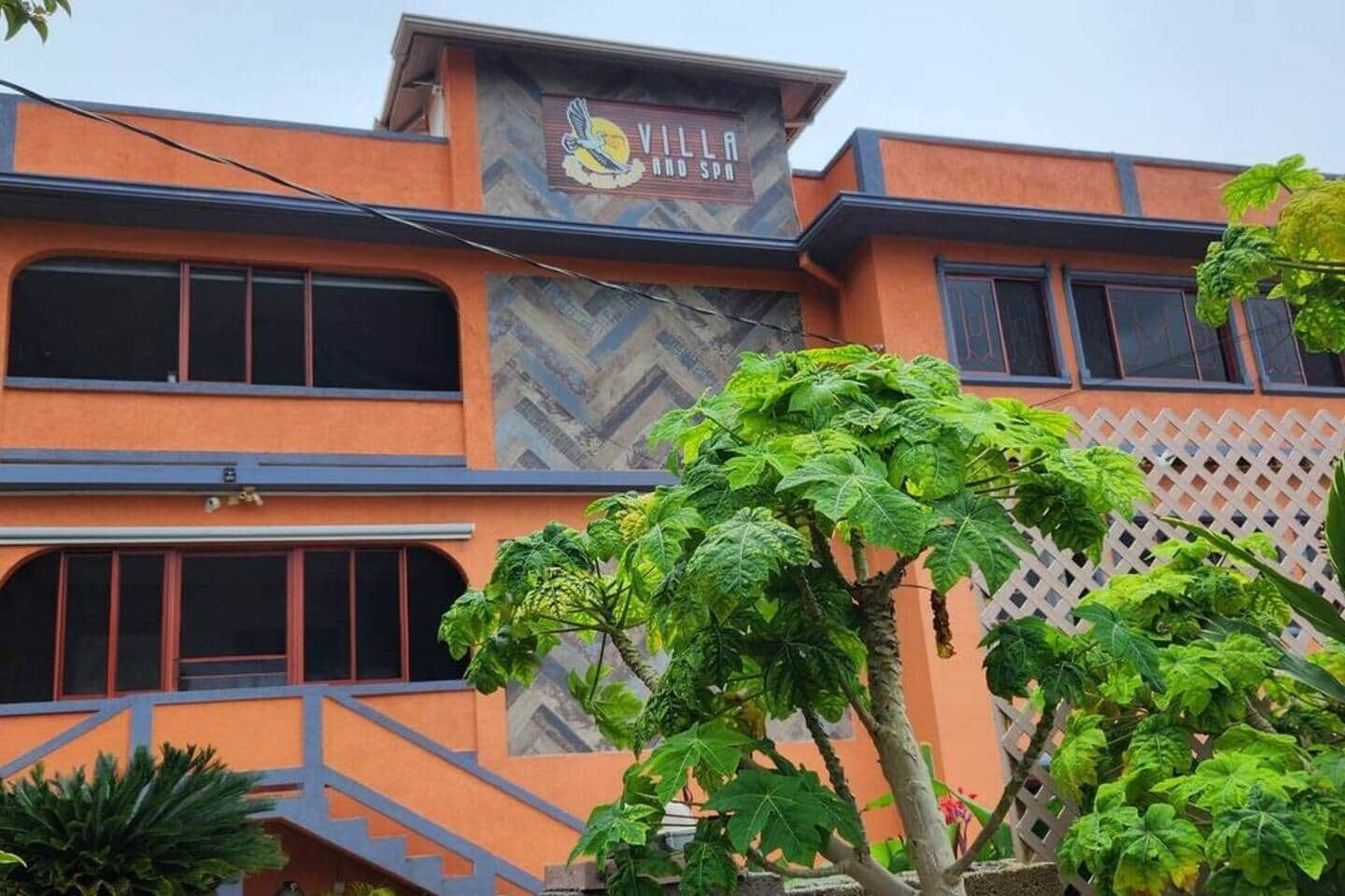 Villa Hotel Spa with a modern architectural design, featuring a prominent sign and a staircase leading to the entrance.