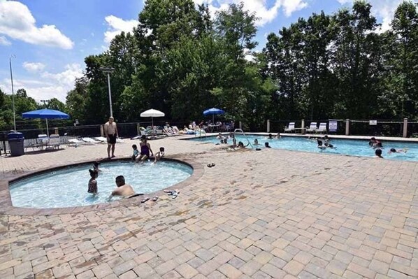 Una piscina pública con varias pistas y un borde de ladrillo alrededor.