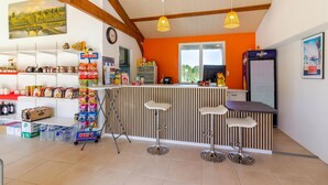 Eine Bar mit einer Theke, Hockstühlen und einem Kühlschrank.