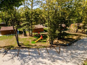 Ein Spielplatz mit Rutsche, Schaukeln und einem umzäunten Bereich.