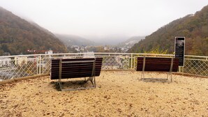 Un banc et un panneau d’information sont installés sur une colline qui offre une vue sur une vallée.