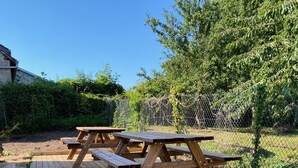 Une terrasse en bois avec des tables de pique-nique.