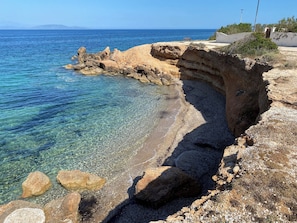 A coastal landscape with clear water, rocky terrain, and a bench. - Peaceful neighborhood 300 m from the beautiful beaches of Artemida Town (ARTEMIDA)