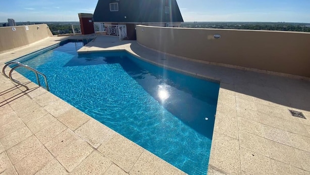 A rooftop swimming pool with a clear view of the city skyline.