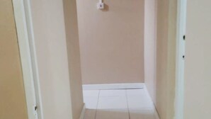 A narrow hallway with white tiled flooring and beige walls. - La Casa Duncy's Studio Apartment Getaway (Yambou River)