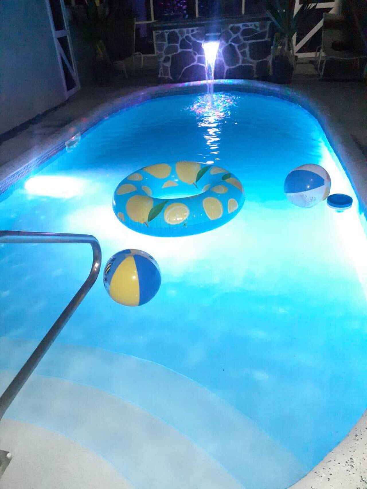 Una piscina con un galleggiante circolare al centro e due galleggianti più piccoli vicino al bordo.