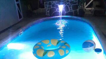 Una piscina con un galleggiante circolare al centro e due galleggianti più piccoli vicino al bordo.