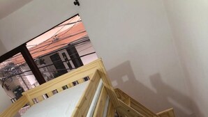 En våningssäng i trä med en madrass och kuddar.