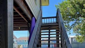 Un escalier en bois menant à l’entrée d’un immeuble.