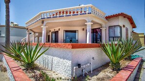 Un bâtiment à deux étages doté d’un balcon, de colonnes et d’un toit recouvert de tuiles.