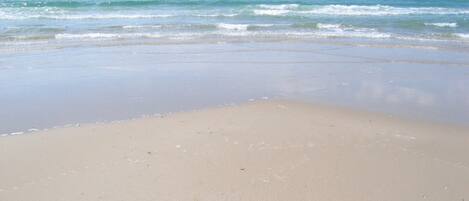 A beach with a clear sky and calm sea.