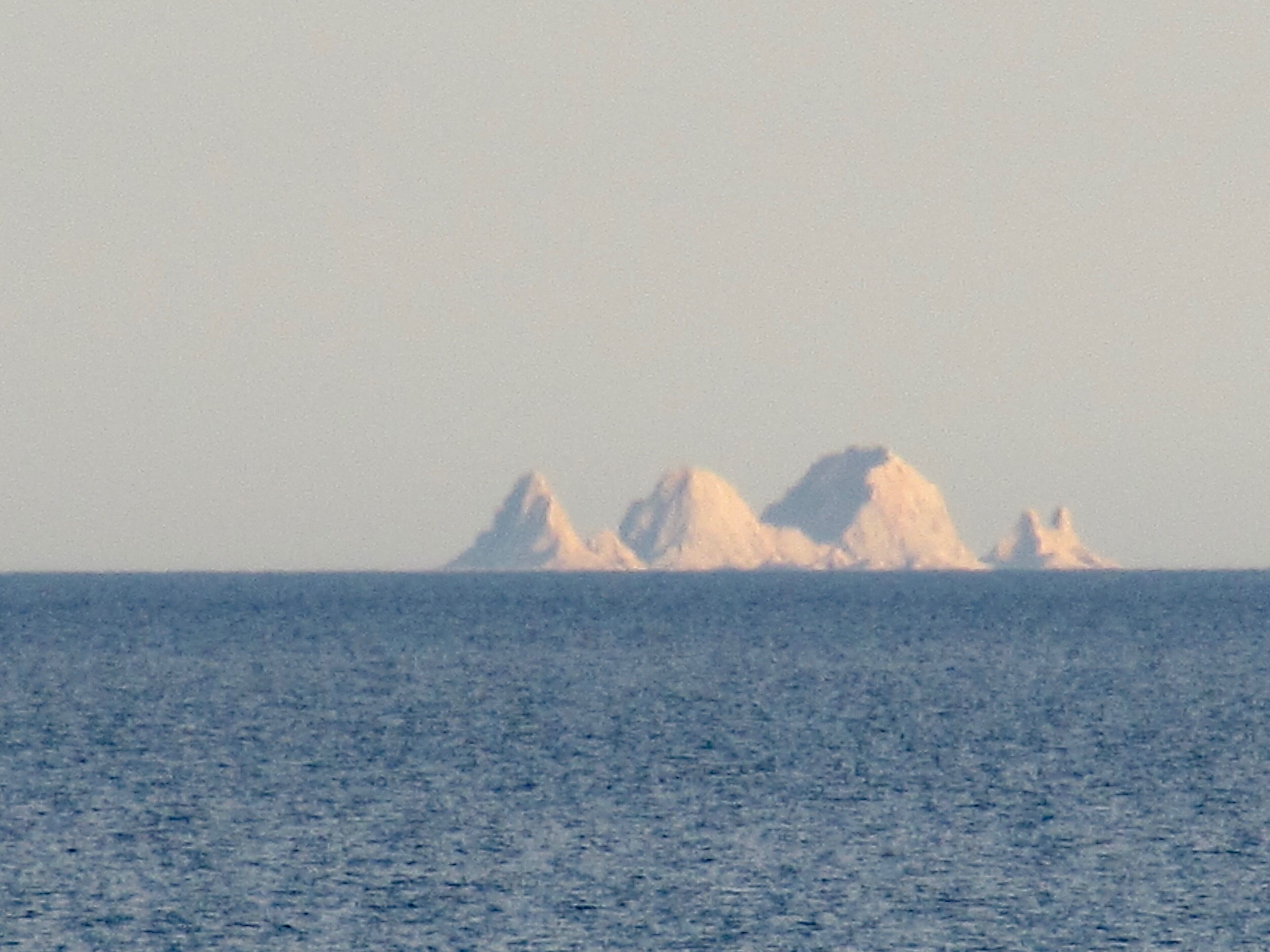 Ett avlägset perspektiv på isberg i havet.