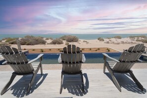 Three Adirondack chairs facing a pool with a view of the beach and ocean. - One-of-a-kind Margaritaville Oceanfront/laguna Shores (Puerto Peñasco)