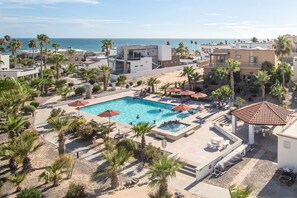 A resort with a central swimming pool surrounded by palm trees and sun loungers. - Casa de Miguel Lux Scenic Gem Newly Renovated Ocean View (Puerto Peñasco)