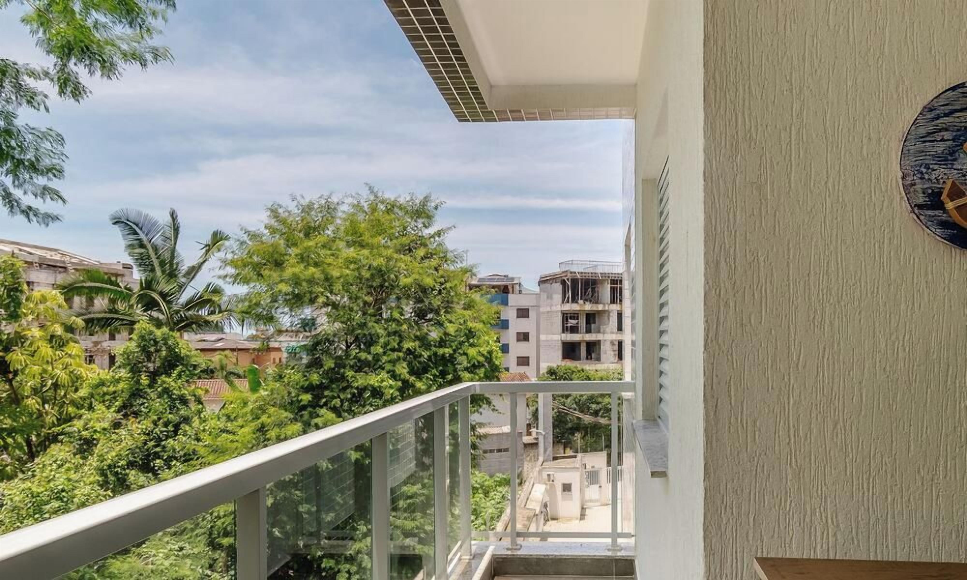 Un balcón con vistas a edificios y árboles circundantes.