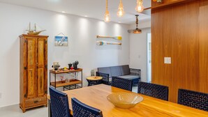 Un comedor con una mesa de madera, sillas azules y un modelo de barco en la pared.