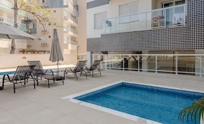A rooftop pool area with lounge chairs and a swimming pool. - Comfort and Leisure 500m From the Beach - Ire0022 (Ubatuba)