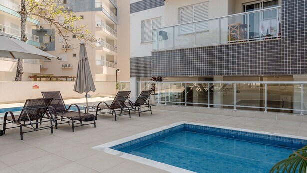 Un área de piscina en la azotea con sillas de descanso y una piscina.