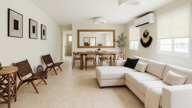 Una sala de estar moderna con un sofá color crema, sillas de madera, una mesa de comedor y un espejo grande.