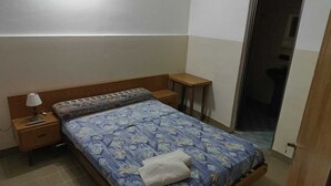 A small, neatly arranged bedroom with a single bed, a bedside table with a lamp, and a nightstand. - Hotel Florentino (Buenos Aires)