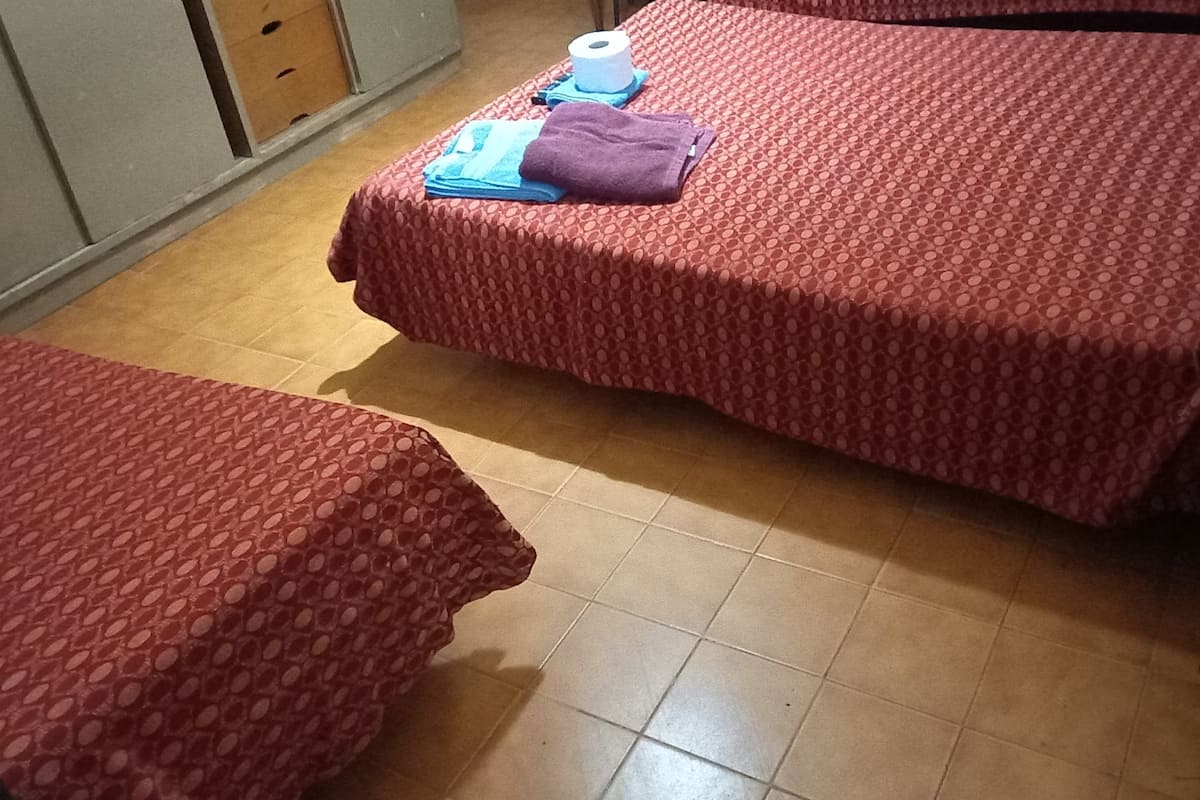 A room with two beds, a desk, and a chair.