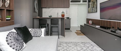 Una sala moderna con cama, comedor y cocina.