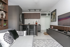 Un salon moderne comprenant un coin nuit, un espace repas et une cuisine.