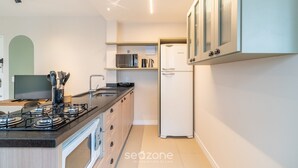 Une cuisine moderne équipée d’une cuisinière à gaz, d’un four à micro-ondes et d’un réfrigérateur.
