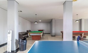 Een recreatieruimte met een pooltafel, biljarttafels en een zithoek.
