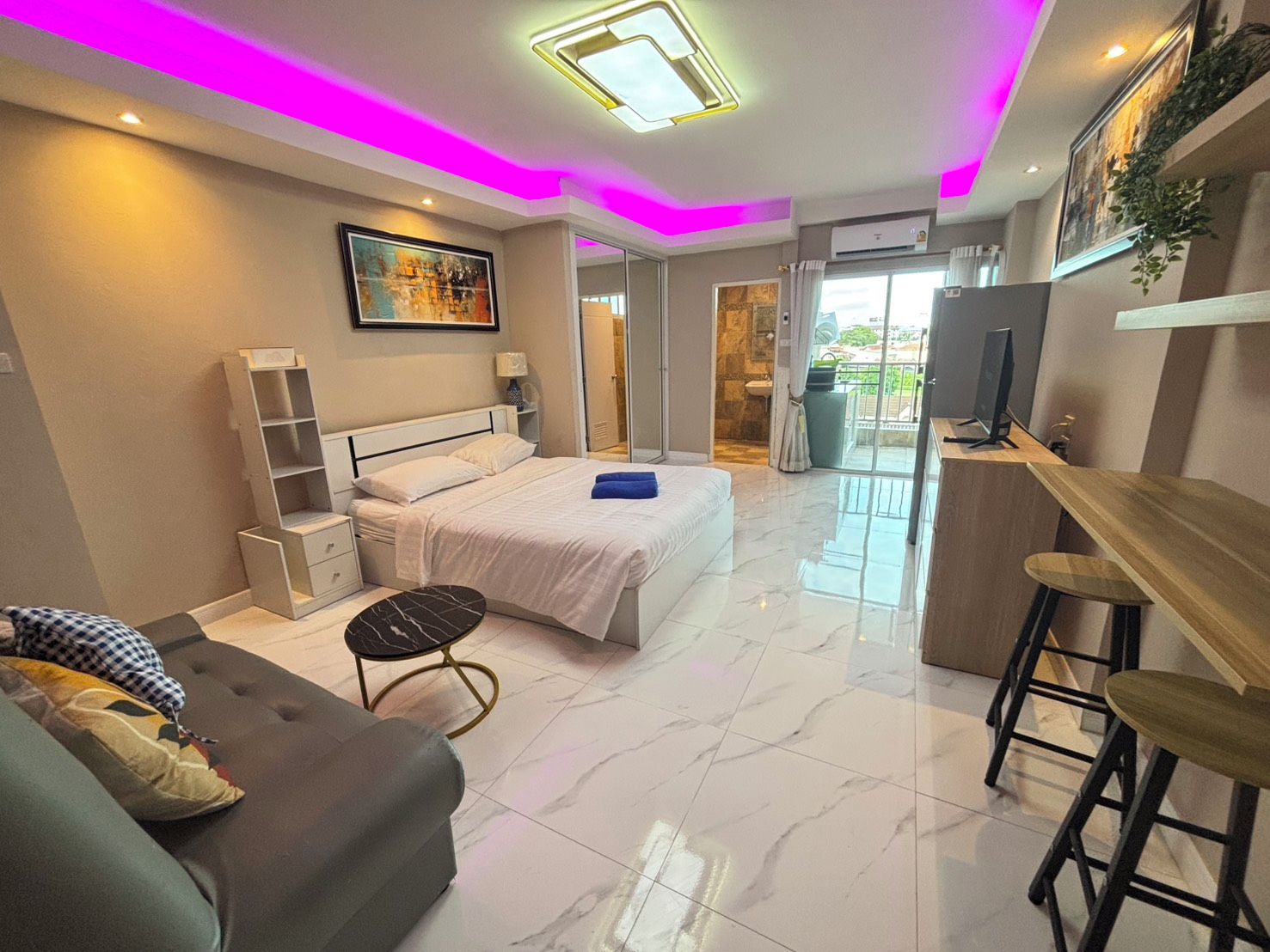 A modern bedroom with a bed, bedside tables, a desk, and a chair.