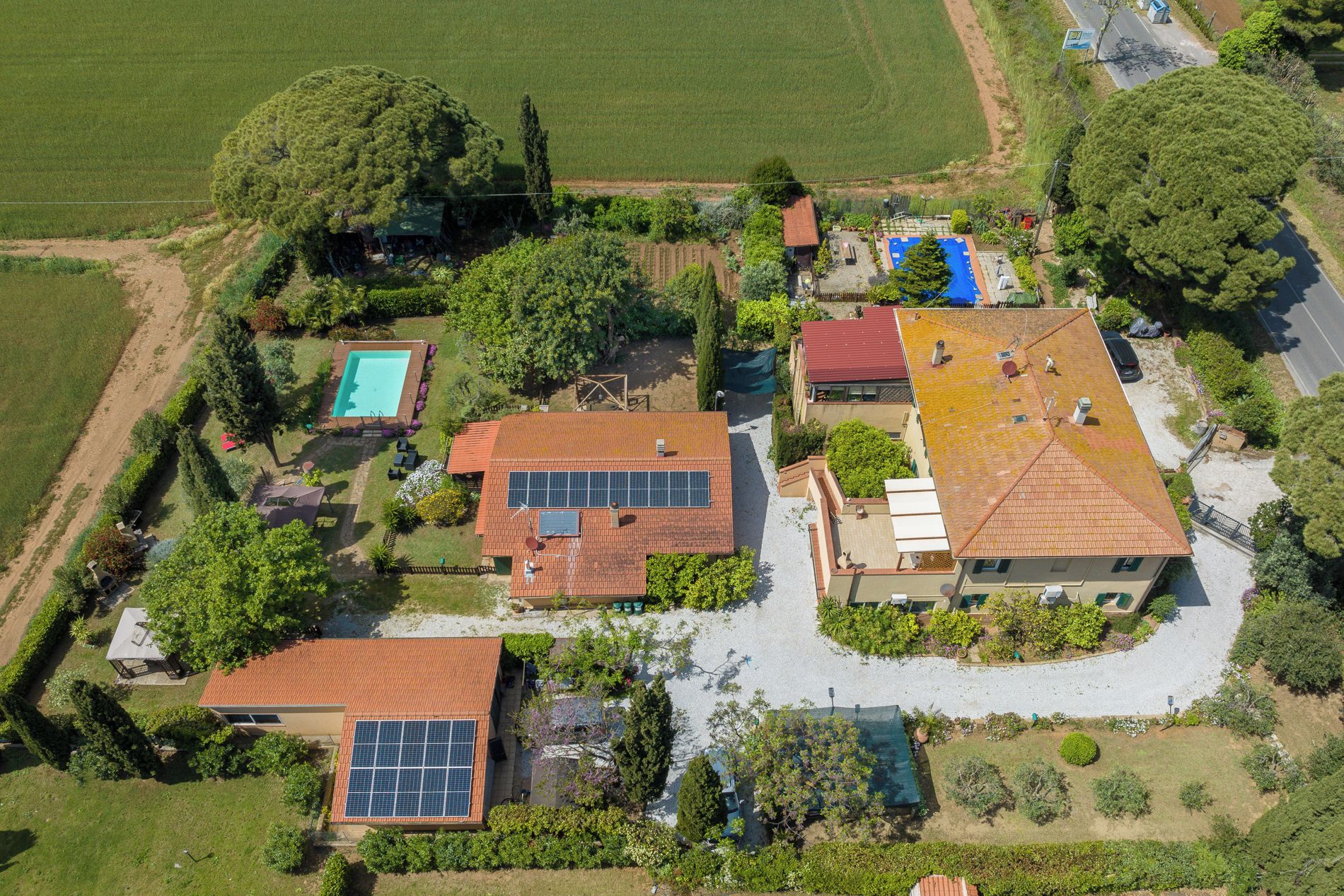 Eine Vogelperspektive eines Wohngebiets mit mehreren Häusern, einem Swimmingpool und Solaranlagen.