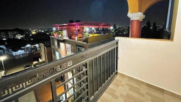 Un balcon donnant sur un immeuble illuminé la nuit.