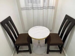 A small dining area with a round table and two chairs.