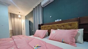 Une chambre d’hôtel avec un lit, une tête de lit et un appareil de climatisation.